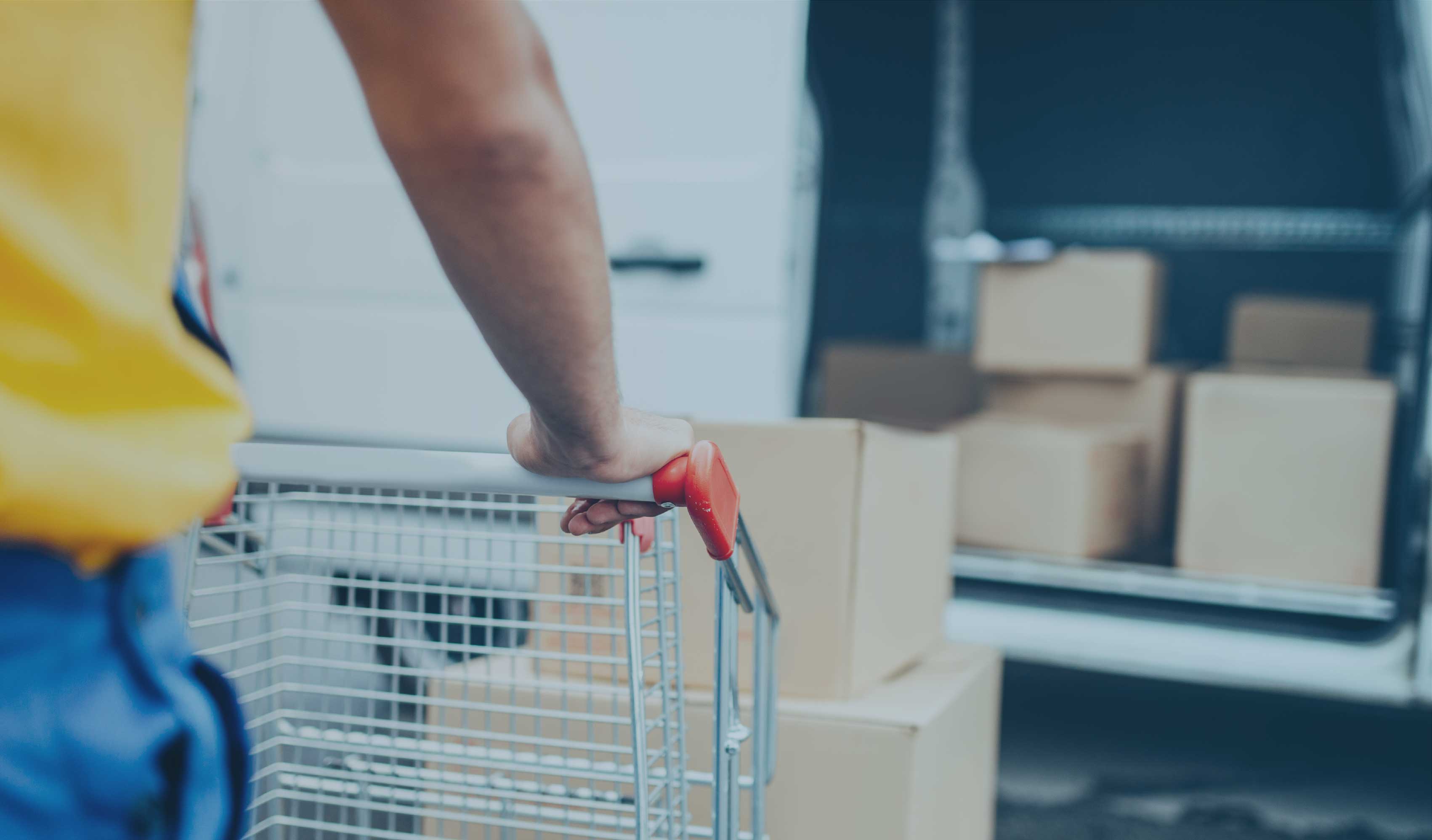 Someone pushing a trolley with boxes